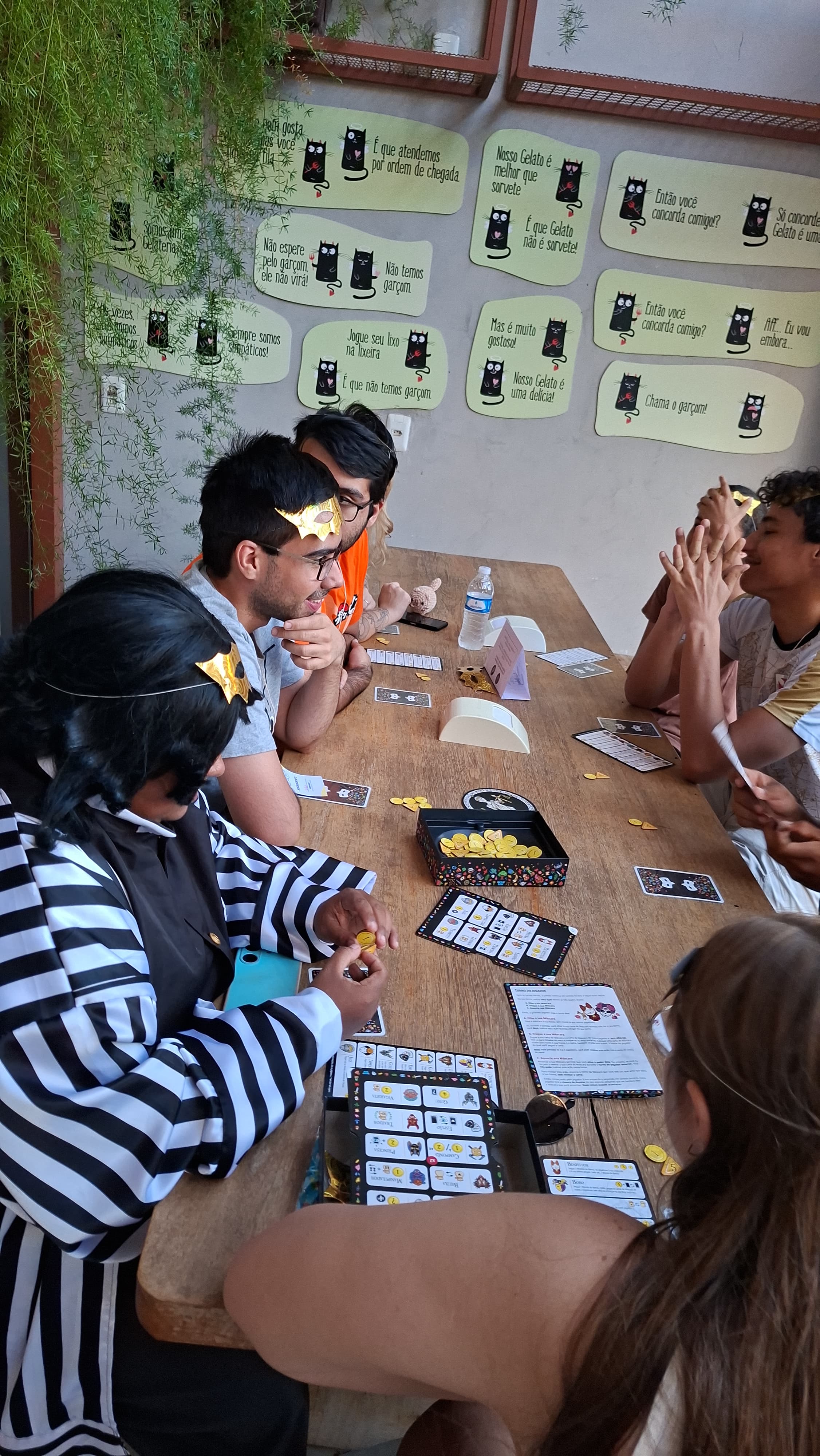 Amigos jogando jogo de cartas com mascaras divertidas